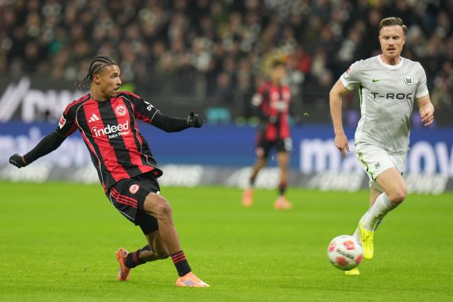 30 November 2025, Hesse, Frankfurt/M.: Frankfurt's Jean Bahoya and Wolfsburg's Yannick Gerhardt battle for the ball during the German Bundesliga soccer match between Eintracht Frankfurt and VfL Wolfsburg at the Deutsche Bank Park. Photo: Thomas Frey/dpa - IMPORTANT NOTICE: DFL and DFB regulations prohibit any use of photographs as image sequences and/or quasi-video.