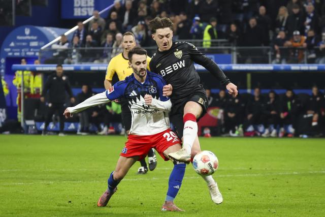 30 November 2025, Hamburg: Hamburger's Fabio Daniel Ferreira Vieira (L) and Stuttgart's Angelo Stiller battle for the ball during the German Bundesliga soccer match between Hamburger SV and VfB Stuttgart at the Volksparkstadion. Photo: Christian Charisius/dpa - IMPORTANT NOTICE: DFL and DFB regulations prohibit any use of photographs as image sequences and/or quasi-video.