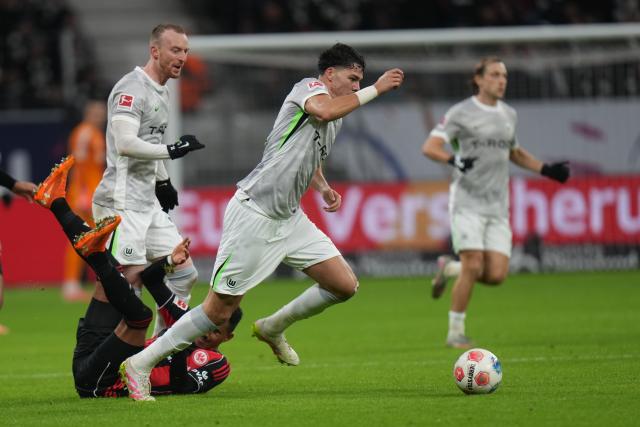 30 November 2025, Hesse, Frankfurt/M.: Eintracht Frankfurt's Ansgar Knauff (L) and Wolfsburg's Aaron Zehnter in action during the German Bundesliga soccer match between Eintracht Frankfurt and VfL Wolfsburg at the Deutsche Bank Park. Photo: Thomas Frey/dpa - IMPORTANT NOTICE: DFL and DFB regulations prohibit any use of photographs as image sequences and/or quasi-video.