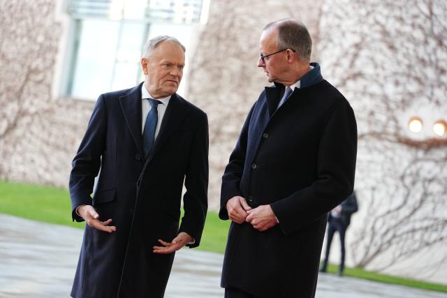 01 December 2025, Berlin: Germany's Chancellor Friedrich Merz (R) welcomes Donald Tusk, Prime Minister of Poland, with military honors in front of the German Chancellery during the German-Polish intergovernmental consultations. Photo: Kay Nietfeld/dpa
