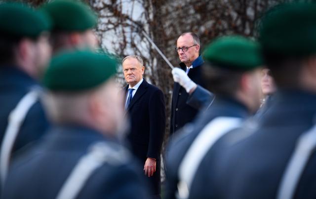 01 December 2025, Berlin: Germany's Chancellor Friedrich Merz (R) welcomes Donald Tusk, Prime Minister of Poland, with military honors in front of the German Chancellery during the German-Polish intergovernmental consultations. Photo: Bernd von Jutrczenka/dpa