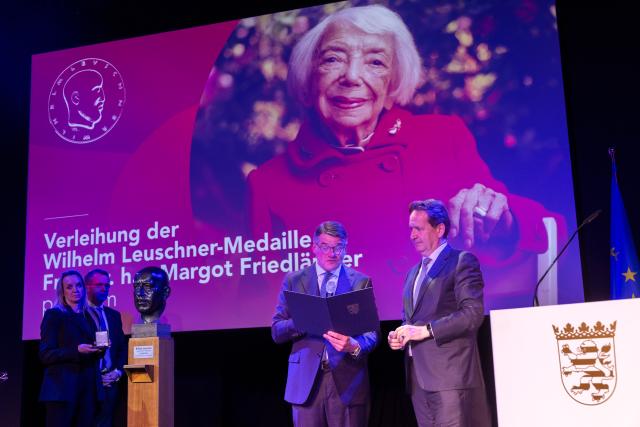 01 December 2025, Hesse, Frankfurt_Main: Hessian Minister President Boris Rhein (C) awards the Chairman of the Margot Friedlaender Foundation, Prof. Dr. Karsten Dreinhoefer (R), with the Wilhelm Leuschner Medal, the state's highest award. Prof. Dr. Dreinhoefer accepted the award on behalf of the late Holocaust survivor Friedlaender. Photo: Helmut Fricke/dpa