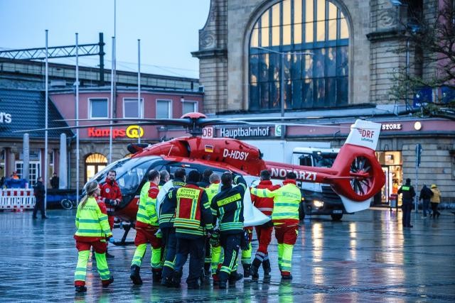02 December 2025, North Rhine-Westphalia, Hagen: Emergency services stand in front of a helicopter after a bus knocked down and seriously injured an eleven-year-old on his way to school in Hagen. According to police, the boy suddenly stepped onto the road at the bus station (ZOB). Photo: Alex Talash/dpa