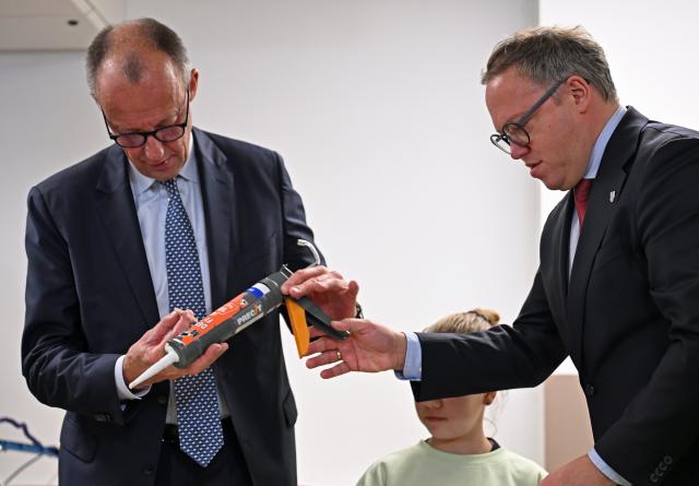 02 December 2025, Thüringen, Jena: German Chancellor Friedrich Merz (L-R) and Mario Voigt, Minister President of Thuringia, make a mosaic with children from the workshop school on the occasion of their inaugural visit to Thuringia. Photo: Jennifer Brückner/dpa