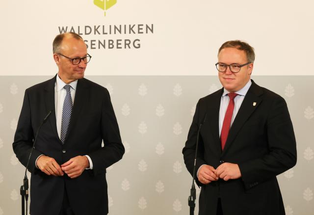 02 December 2025, Thueringen, Eisenberg: German Chancellor Friedrich Merz (l) and Mario Voigt, Minister President of Thuringia, make a statement during a visit to the Waldkliniken Eisenberg on the occasion of their inaugural visit to Thuringia. Photo: Bodo Schackow/dpa
