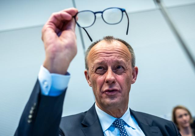 02 December 2025, Berlin: German Chancellor Friedrich Merz cleans his glasses before the start of the parliamentary group meeting in the Bundestag. Photo: Michael Kappeler/dpa
