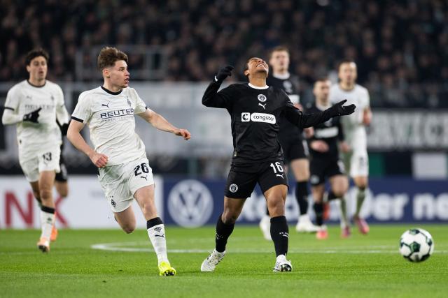 02 December 2025, North Rhine-Westphalia, Moenchengladbach: Moenchengladbach's Lukas Ullrich (L) and Pauli's Joel Fujita battle for the ball during the German DFB Cup round of 16 soccer match between Borussia Moenchengladbach and FC St. Pauli at Borussia-Park. Photo: Rolf Vennenbernd/dpa - IMPORTANT NOTICE: DFL and DFB regulations prohibit any use of photographs as image sequences and/or quasi-video.
