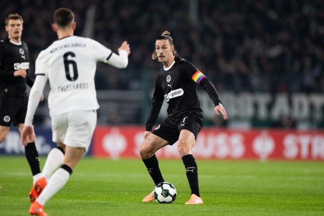 02 December 2025, North Rhine-Westphalia, Moenchengladbach: Moenchengladbach's Yannik Engelhardt (L) and Pauli's Jackson Irvine battle for the ball during the German DFB Cup round of 16 soccer match between Borussia Moenchengladbach and FC St. Pauli at Borussia-Park. Photo: Rolf Vennenbernd/dpa - IMPORTANT NOTICE: DFL and DFB regulations prohibit any use of photographs as image sequences and/or quasi-video.
