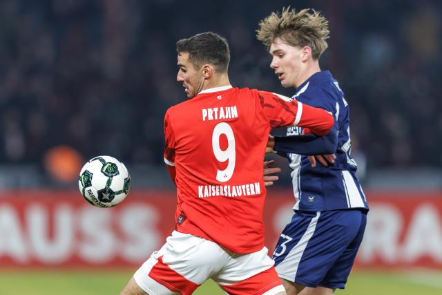 02 December 2025, Berlin: Kaiserslautern's Ivan Prtajin (L) and Hertha's Kennet Eichhorn battle for the ball during the German DFB Cup round of 16 soccer match between Hertha BSC and 1. FC Kaiserslautern at Olympiastadion. Photo: Andreas Gora/dpa - WICHTIGER HINWEIS: Gemäß den Vorgaben der DFL Deutsche Fußball Liga bzw. des DFB Deutscher Fußball-Bund ist es untersagt, in dem Stadion und/oder vom Spiel angefertigte Fotoaufnahmen in Form von Sequenzbildern und/oder videoähnlichen Fotostrecken zu verwerten bzw. verwerten zu lassen.