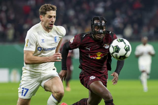 02 December 2025, Saxony, Leipzig: Magdeburg's Alexander Nollenberger (L) and Leipzig's Yan Diomande battle for the ball during the German DFB Cup round of 16 soccer match between RB Leipzig and 1. FC Magdeburg at Red Bull Arena. Photo: Jan Woitas/dpa - WICHTIGER HINWEIS: Gemäß den Vorgaben der DFL Deutsche Fußball Liga bzw. des DFB Deutscher Fußball-Bund ist es untersagt, in dem Stadion und/oder vom Spiel angefertigte Fotoaufnahmen in Form von Sequenzbildern und/oder videoähnlichen Fotostrecken zu verwerten bzw. verwerten zu lassen.