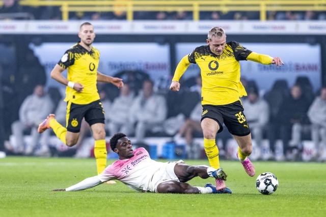 02 December 2025, North Rhine-Westphalia, Dortmund: Borussia Dortmund's Julian Ryerson (R) and Leverkusen's Ernest Poku battle for the ball during the German DFB Cup soccer match between Borussia Dortmund and Bayer Leverkusen at the Signal Iduna Park. Photo: David Inderlied/dpa - WICHTIGER HINWEIS: Gemäß den Vorgaben der DFL Deutsche Fußball Liga bzw. des DFB Deutscher Fußball-Bund ist es untersagt, in dem Stadion und/oder vom Spiel angefertigte Fotoaufnahmen in Form von Sequenzbildern und/oder videoähnlichen Fotostrecken zu verwerten bzw. verwerten zu lassen.