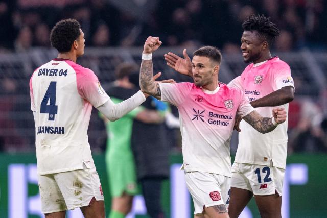 02 December 2025, North Rhine-Westphalia, Dortmund: (L-R) Bayer Leverkusen's Jarell Quansah, Alex Grimaldo and Edmond Tapsoba celebrate after the German DFB Cup soccer match between Borussia Dortmund and Bayer Leverkusen at the Signal Iduna Park. Photo: David Inderlied/dpa - WICHTIGER HINWEIS: Gemäß den Vorgaben der DFL Deutsche Fußball Liga bzw. des DFB Deutscher Fußball-Bund ist es untersagt, in dem Stadion und/oder vom Spiel angefertigte Fotoaufnahmen in Form von Sequenzbildern und/oder videoähnlichen Fotostrecken zu verwerten bzw. verwerten zu lassen.