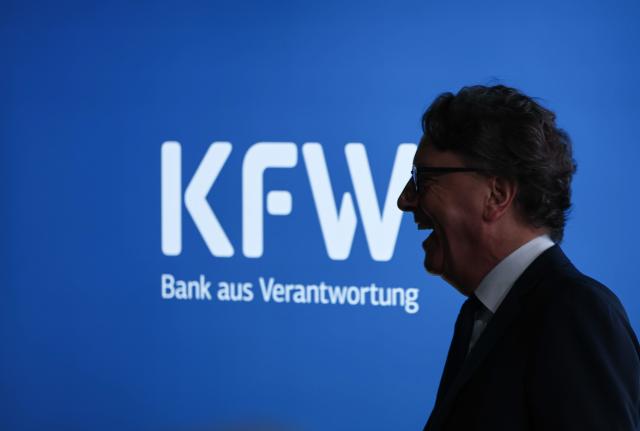03 December 2025, Hesse, Frankfurt/Main: Stefan Wintels, CEO of KfW, stands laughing in front of a monitor with KfW lettering at the "Energy and Infrastructure" capital market conference. Photo: Hannes P. Albert/dpa