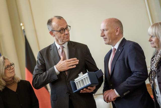 03 December 2025, Berlin: German Chancellor Friedrich Merz accepts his gift, a porcelain Brandenburg Gate, from Kai Wegner, Governing Mayor of Berlin, during his official inaugural visit to Berlin in the Rotes Rathaus. Photo: Michael Kappeler/dpa
