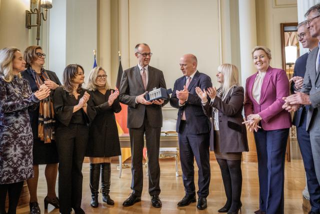 03 December 2025, Berlin: German Chancellor Friedrich Merz accepts his gift, a porcelain Brandenburg Gate, from Kai Wegner, Governing Mayor of Berlin, during his official inaugural visit to Berlin in the Rotes Rathaus. Photo: Michael Kappeler/dpa