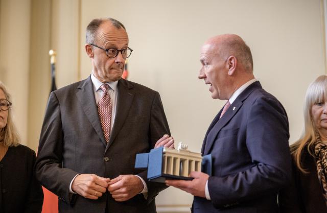 03 December 2025, Berlin: German Chancellor Friedrich Merz (L) receives his gift, a porcelain Brandenburg Gate, from Kai Wegner, Governing Mayor of Berlin, during his official inaugural visit to Berlin in the Rotes Rathaus. Photo: Michael Kappeler/dpa