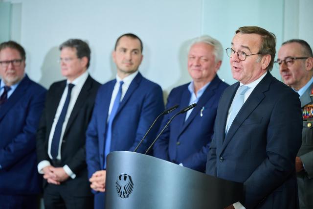 03 December 2025, Berlin: Boris Pistorius (2-R), German Minister of Defence, speaks at the press statement in the Federal Ministry of Defence, while Arne Hanssen (L-R), Senior Program Manager at Systematic, Christian Leicher, Chairman of the Management Board of Rohde und Schwarz, Joel Langenberg, Managing Director of blackned GmbH, Armin Papperger, CEO of Rheinmetall and Carsten Breuer (R), Inspector General of the Bundeswehr, stand behind him. Pistorius receives representatives of companies involved in the digitalization of land-based operations (D-LBO): The armaments project aims to digitize communication for combat. Photo: Annette Riedl/dpa