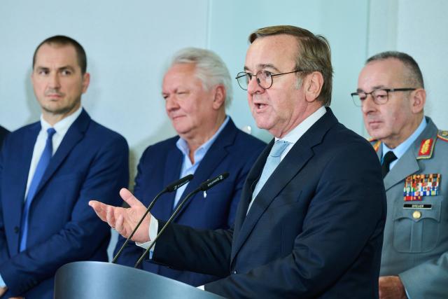 03 December 2025, Berlin: Boris Pistorius (2-R), German Minister of Defense speaks at the press statement in the Federal Ministry of Defense, while Armin Papperger (2-L), CEO of Rheinmetall, Joel Langenberg (l), Managing Director of blackned GmbH and Carsten Breuer (r), Inspector General of the Bundeswehr stand behind him. Pistorius receives representatives of companies involved in the digitization of land-based operations (D-LBO): The armaments project aims to digitize communication for combat. Photo: Annette Riedl/dpa