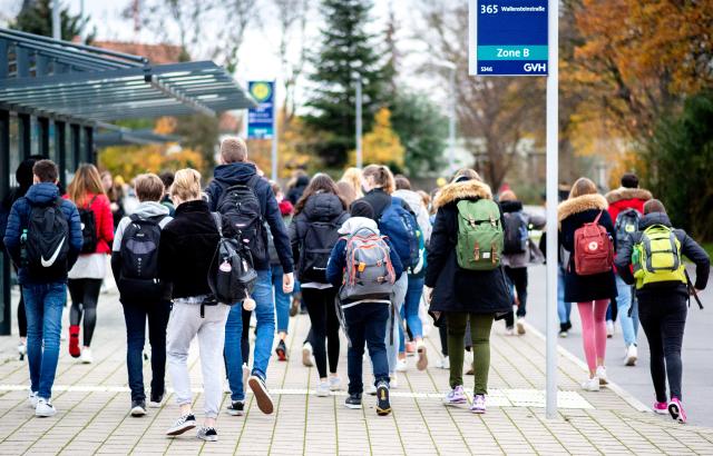FILED - 20 November 2020, Lower Saxony, Duesseldorf: Students walk from a bus stop to their school with their backpacks. Photo: Hauke-Christian Dittrich/dpa
