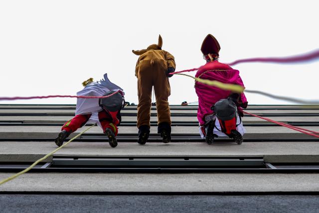 03 December 2025, North Rhine-Westphalia, Duisburg: Height rescuers, dressed as Santa Claus, angels and reindeer, abseil down from a building at the Duisburg Heart Center, where they are delivering presents to young patients at the Children's Heart Center in Duisburg. Photo: Christoph Reichwein/dpa