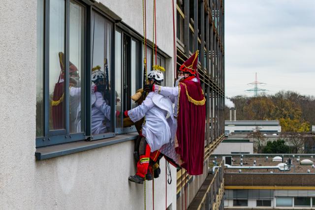 03 December 2025, North Rhine-Westphalia, Duisburg: Height rescuers, dressed as Santa Claus, angels and reindeer, abseil down from a building at the Duisburg Heart Center, where they are delivering presents to young patients at the Children's Heart Center in Duisburg. Photo: Christoph Reichwein/dpa