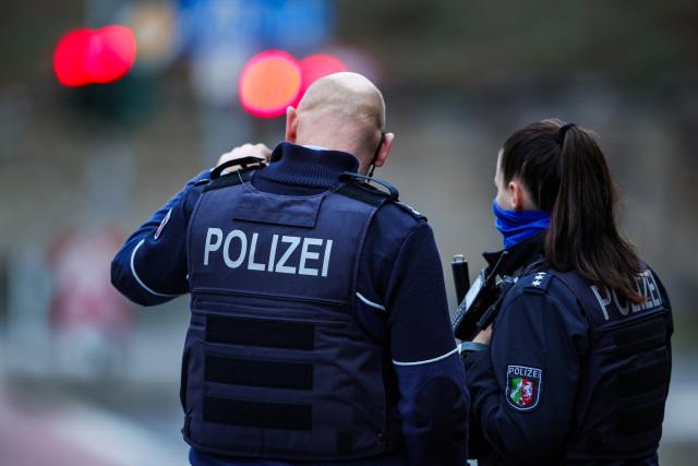 12 March 2025, North Rhine-Westphalia, Moenchengladbach: Police officers confer at Bismarckplatz in Moenchengladbach city center. Photo: Christoph Reichwein/dpa