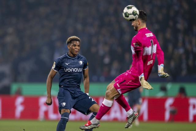 03 December 2024, North Rhine-Westphalia, Bochum: Bochum's Farid Alfa-Ruprecht (L) and Stuttgart goalkeeper Fabian Bredlow battle for the ball during the German DFB Cup round of 16 soccer match between VfL Bochum and VfB Stuttgart at Vonovia Ruhrstadion. Photo: David Inderlied/dpa - IMPORTANT NOTICE: DFL and DFB regulations prohibit any use of photographs as image sequences and/or quasi-video.