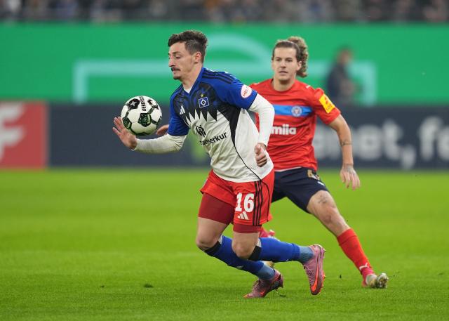 03 December 2025, Hamburg: Hamburger's Giorgi Gocholeishvili (L) and Holstein Kiel's John Tolkin battle for the ball during the German DFB Cup round of 16 soccer match between Hamburger SV and Holstein Kiel at the Volksparkstadion. Photo: Marcus Brandt/dpa - WICHTIGER HINWEIS: Gemäß den Vorgaben der DFL Deutsche Fußball Liga bzw. des DFB Deutscher Fußball-Bund ist es untersagt, in dem Stadion und/oder vom Spiel angefertigte Fotoaufnahmen in Form von Sequenzbildern und/oder videoähnlichen Fotostrecken zu verwerten bzw. verwerten zu lassen.