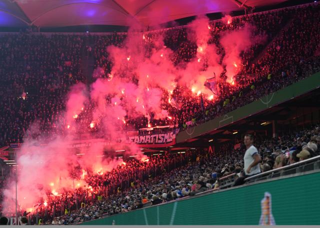 03 December 2025, Hamburg: Kiel fans set off fireworks in the stands during the German DFB Cup round of 16 soccer match between Hamburger SV and Holstein Kiel at the Volksparkstadion. Photo: Marcus Brandt/dpa - WICHTIGER HINWEIS: Gemäß den Vorgaben der DFL Deutsche Fußball Liga bzw. des DFB Deutscher Fußball-Bund ist es untersagt, in dem Stadion und/oder vom Spiel angefertigte Fotoaufnahmen in Form von Sequenzbildern und/oder videoähnlichen Fotostrecken zu verwerten bzw. verwerten zu lassen.