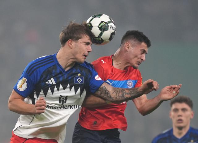 03 December 2025, Hamburg: Hamburger's Luka VuskoviZc (L) and Holstein Kiel's Adrian Kapralik battle for the ball during the German DFB Cup round of 16 soccer match between Hamburger SV and Holstein Kiel at the Volksparkstadion. Photo: Marcus Brandt/dpa - WICHTIGER HINWEIS: Gemäß den Vorgaben der DFL Deutsche Fußball Liga bzw. des DFB Deutscher Fußball-Bund ist es untersagt, in dem Stadion und/oder vom Spiel angefertigte Fotoaufnahmen in Form von Sequenzbildern und/oder videoähnlichen Fotostrecken zu verwerten bzw. verwerten zu lassen.