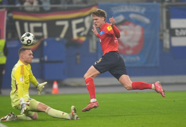 03 December 2025, Hamburg: Holstein Kiel's Phil Harres (R) and Hamburger goalkeeper Daniel Peretz battle for the ball during the German DFB Cup round of 16 soccer match between Hamburger SV and Holstein Kiel at the Volksparkstadion. Photo: Marcus Brandt/dpa - WICHTIGER HINWEIS: Gemäß den Vorgaben der DFL Deutsche Fußball Liga bzw. des DFB Deutscher Fußball-Bund ist es untersagt, in dem Stadion und/oder vom Spiel angefertigte Fotoaufnahmen in Form von Sequenzbildern und/oder videoähnlichen Fotostrecken zu verwerten bzw. verwerten zu lassen.