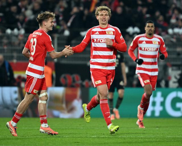03 December 2025, Berlin: Union Berlin's Leopold Querfeld (C) celebrates scoring his side's second goal with teammates András Schaefer (L) and Danilho Doekhi during the German DFB Cup round of 16 soccer match between 1. FC Union Berlin and FC Bayern Munich at an der Alten Foersterei. Photo: Soeren Stache/dpa - IMPORTANT NOTE: In accordance with the regulations of the DFL German Football League and the DFB German Football Association, it is prohibited to utilize or have utilized photographs taken in the stadium and/or of the match in the form of sequential images and/or video-like photo series.