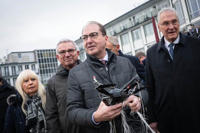 04 December 2025, Bremen: Alexander Dobrindt, Germany's Minister of the Interior, holds an intercepted drone during a Federal Police demonstration on drone defense. The Conference of Interior Ministers (IMK) is focusing on topics including drone detection and defense, hybrid threats and the introduction of the new European asylum system (GEAS). Photo: Sina Schuldt/dpa
