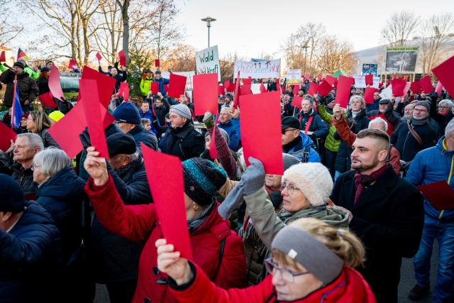 04 December 2025, Thuringia, Erfurt: Demonstrators from the alliance "Thuringian citizens' initiatives against wind power" hold up red cards in front of the Thuringian state parliament. The demonstration is directed against the planned amendment to the Thuringian law on the further development of the state forestry authority and the forest protection situation threatening forests. Photo: Jacob Schröter/dpa