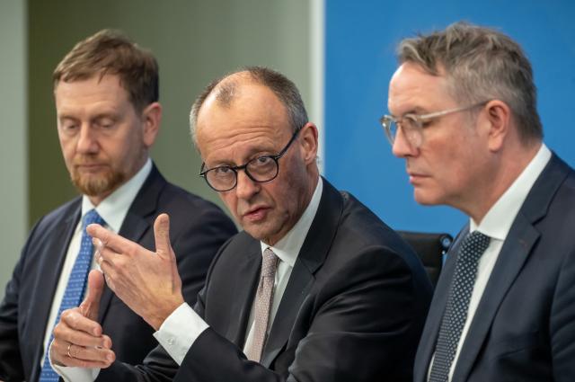04 December 2025, Berlin: German Chancellor Friedrich Merz (C) speaks during a press conference with Michael Kretschmer (L), Minister President of Saxony, and Alexander Schweitzer, Minister President of Rhineland-Palatinate, after the Minister Presidents' Conference with the heads of the federal states. Photo: Michael Kappeler/dpa