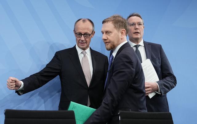 04 December 2025, Berlin: German Chancellor Friedrich Merz (C) takes part in a press conference with Michael Kretschmer (L), Minister President of Saxony, and Alexander Schweitzer, Minister President of Rhineland-Palatinate, after the Minister Presidents' Conference with the heads of the federal states. Photo: Michael Kappeler/dpa
