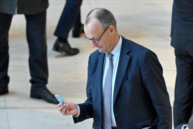 05 December 2025, Berlin: Germany's Chancellor Friedrich Merz casts his voting card in the German Bundestag during a roll-call vote on the law for a new military service. Photo: Christophe Gateau/dpa