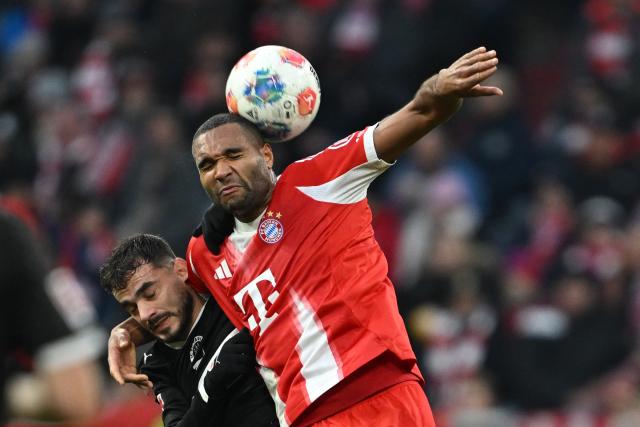 29 November 2025, Bavaria, Munich: St. Pauli's Danel Sinani (L) and Bayern Munich's Jonathan Tah battle for the ball during the German Bundesliga soccer match between Bayern Munich and FC St. Pauli at Allianz Arena. Photo: Sven Hoppe/dpa - IMPORTANT NOTICE: DFL and DFB regulations prohibit any use of photographs as image sequences and/or quasi-video.