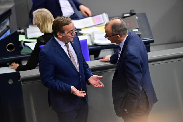 05 December 2025, Berlin: Boris Pistorius (L), Germany's of Defence Minister, and Germany's Chancellor Friedrich Merz speak on the sidelines of the German Bundestag session. Photo: Christophe Gateau/dpa