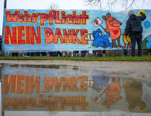 05 December 2025, Brandenburg, Cottbus: A student sprays graffiti reading 'Conscription, no thanks' during the nationwide school strike and student protest against the introduction of compulsory military service. Photo: Patrick Pleul/dpa