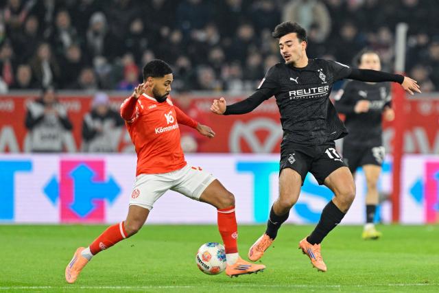 05 December 2025, Rhineland-Palatinate, Mainz: Mainz' Phillipp Mwene (L) and Gladbach's Tim Kleindienst battle for the ball during the German Bundesliga soccer match between FSV Mainz 05 and Borussia Moenchengladbach at Mewa Arena. Photo: Uwe Anspach/dpa - IMPORTANT NOTICE: DFL and DFB regulations prohibit any use of photographs as image sequences and/or quasi-video.