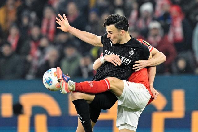 05 December 2025, Rhineland-Palatinate, Mainz: Mainz' Andreas Hanche-Olsen (L) and Gladbach's Haris Tabakovic battle for the ball during the German Bundesliga soccer match between FSV Mainz 05 and Borussia Moenchengladbach at Mewa Arena. Photo: Uwe Anspach/dpa - IMPORTANT NOTICE: DFL and DFB regulations prohibit any use of photographs as image sequences and/or quasi-video.