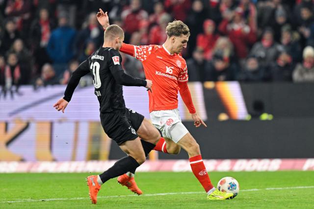 05 December 2025, Rhineland-Palatinate, Mainz: Gladbach's Nico Elvedi (L) and Mainz Nelson Weiper battle for the ball during the German Bundesliga soccer match between FSV Mainz 05 and Borussia Moenchengladbach at Mewa Arena. Photo: Uwe Anspach/dpa - IMPORTANT NOTICE: DFL and DFB regulations prohibit any use of photographs as image sequences and/or quasi-video.