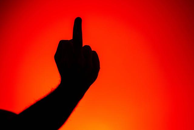 Eine Person zeigt den Mittelfinger, auch Stinkefinger genannt.