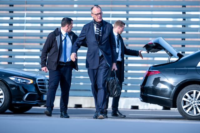 06 December 2025, Brandenburg, Schönefeld: Germany's Chancellor Friedrich Merz (C) arrives at BER Airport to depart for his inaugural visits to Jordan and Israel. Photo: Michael Kappeler/dpa