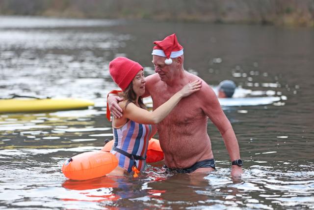 06 December 2025, Lower Saxony, Goslar: Two participants take part in the traditional St. Nicholas swim, where the swimmers enter the three-degree water of the Herzberg pond at an air temperature of just under four degrees. Photo: Matthias Bein/dpa