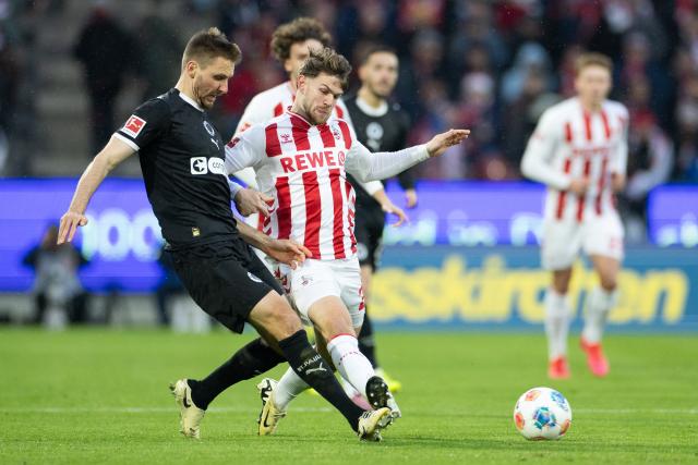 06 December 2025, North Rhine-Westphalia, Cologne: Cologne's Jan Thielmann (R) and Pauli's Karol Mets battle for the ball during the German Bundesliga soccer match between 1. FC Cologne and FC St. Pauli at the RheinEnergieStadion. Photo: Rolf Vennenbernd/dpa - IMPORTANT NOTICE: DFL and DFB regulations prohibit any use of photographs as image sequences and/or quasi-video.