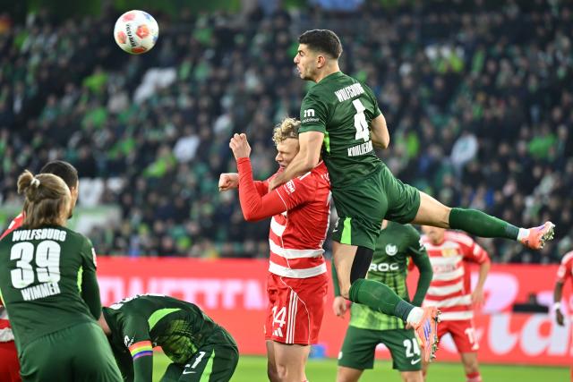 06 December 2025, Lower Saxony, Wolfsburg: Wolfsburg's Konstantinos Koulierakis and Union Berlin's Leopold Querfeld battle for the ball during the German Bundesliga soccer match between VfL Wolfsburg and 1. FC Union Berlin at the Volkswagen Arena. Photo: Swen Pförtner/dpa - IMPORTANT NOTICE: DFL and DFB regulations prohibit any use of photographs as image sequences and/or quasi-video.