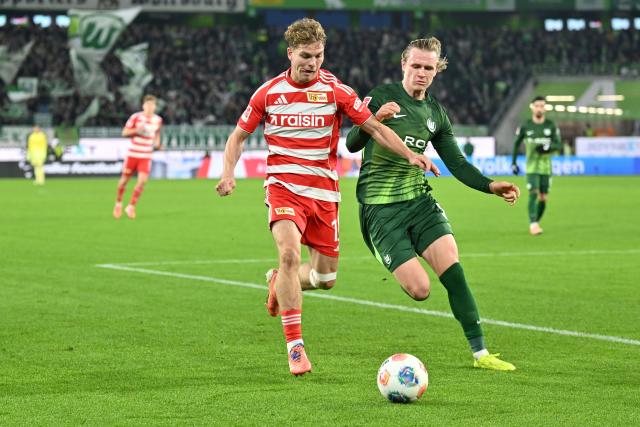 06 December 2025, Lower Saxony, Wolfsburg: Union Berlin's Andras Schaefer (L) and Wolfsburg's Patrick Wimmer in action during the German Bundesliga soccer match between VfL Wolfsburg and 1. FC Union Berlin at the Volkswagen Arena. Photo: Swen Pförtner/dpa - IMPORTANT NOTICE: DFL and DFB regulations prohibit any use of photographs as image sequences and/or quasi-video.