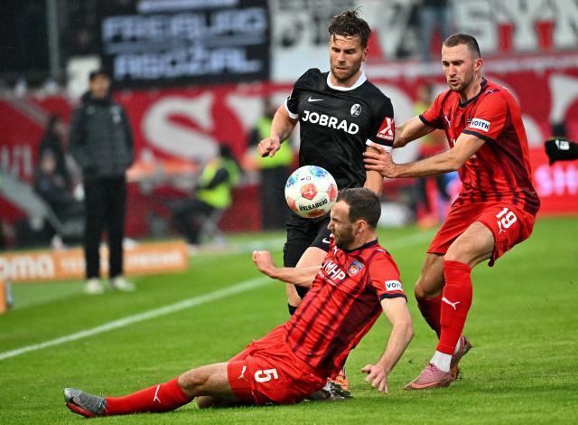 06 December 2025, Baden-Württemberg, Heidenheim: Heidenheim's Benedikt Gimber and Jonas Föhrenbach in action against Freiburg's Lucas Hoeler during German Bundesliga soccer match between FC Heidenheim and SC Freiburg at the Voith-Arena. Photo: Jan-Philipp Strobel/dpa - IMPORTANT NOTICE: DFL and DFB regulations prohibit any use of photographs as image sequences and/or quasi-video.